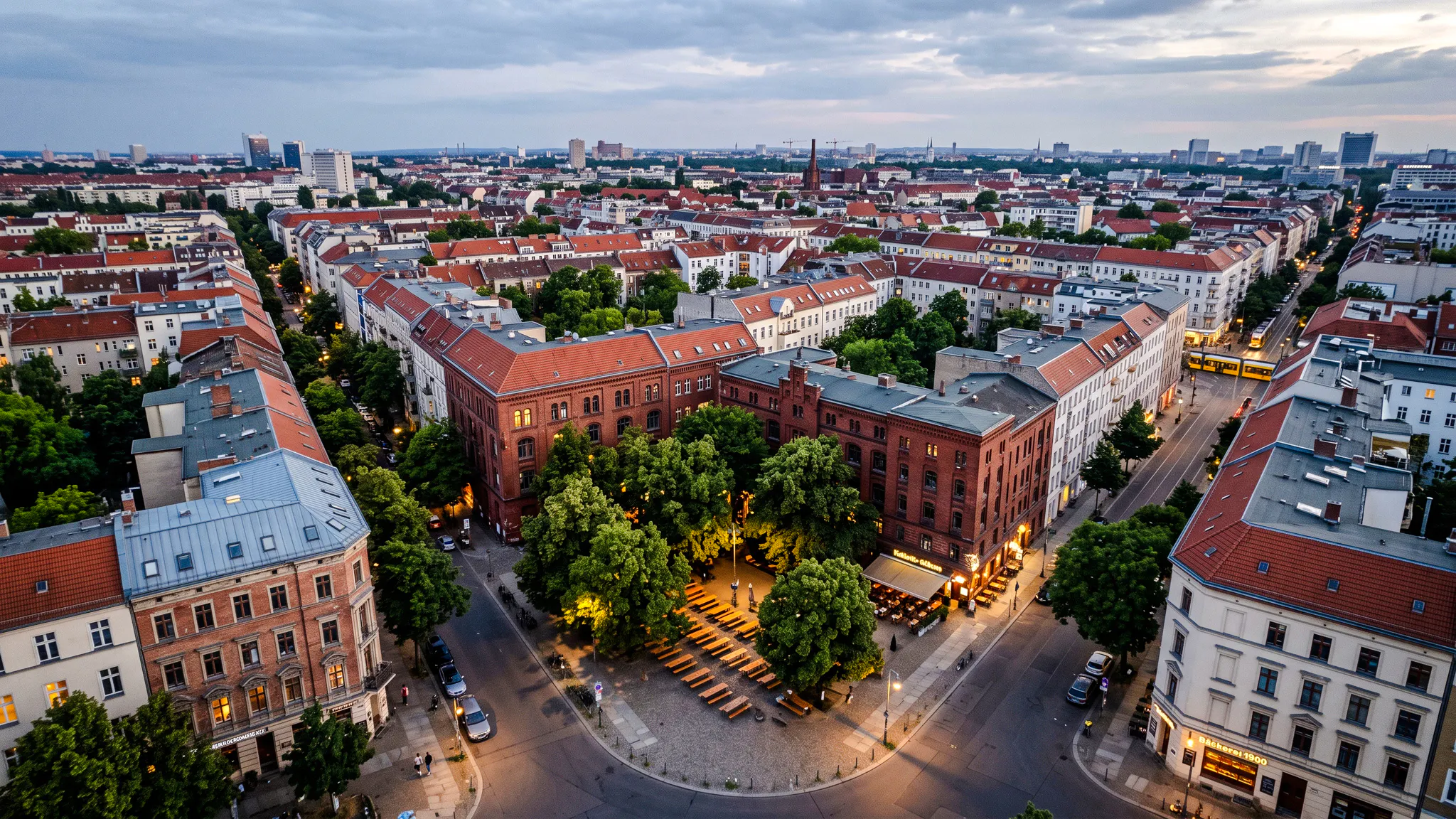 Aerial view of Berlin neighborhood with historic buildings and outdoor seating area, part of Oktoberfest walking tour.