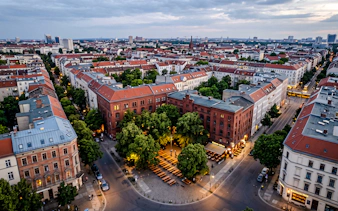 Aerial view of Berlin neighborhood with historic buildings and outdoor seating area, part of Oktoberfest walking tour.
