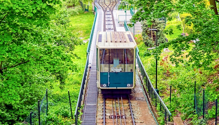 Funicular ascending Petrin Hill in Prague, Czech Republic, surrounded by lush greenery.