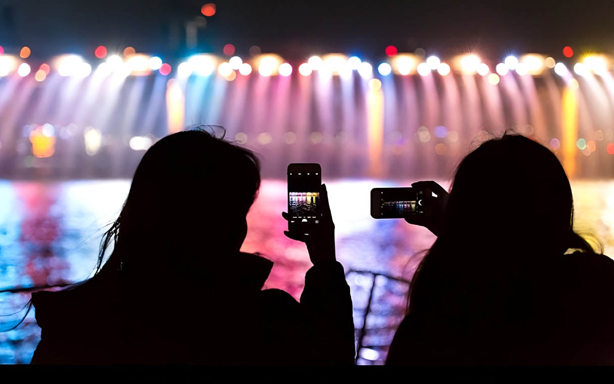 Silhouettes capturing Banpo Bridge rainbow fountain on Han River Marina Yacht.
