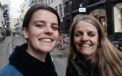 Two people smiling on a street in Copenhagen during a self-guided city exploration game.