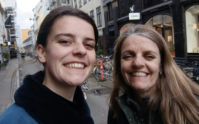 Two people smiling on a street in Copenhagen during a self-guided city exploration game.