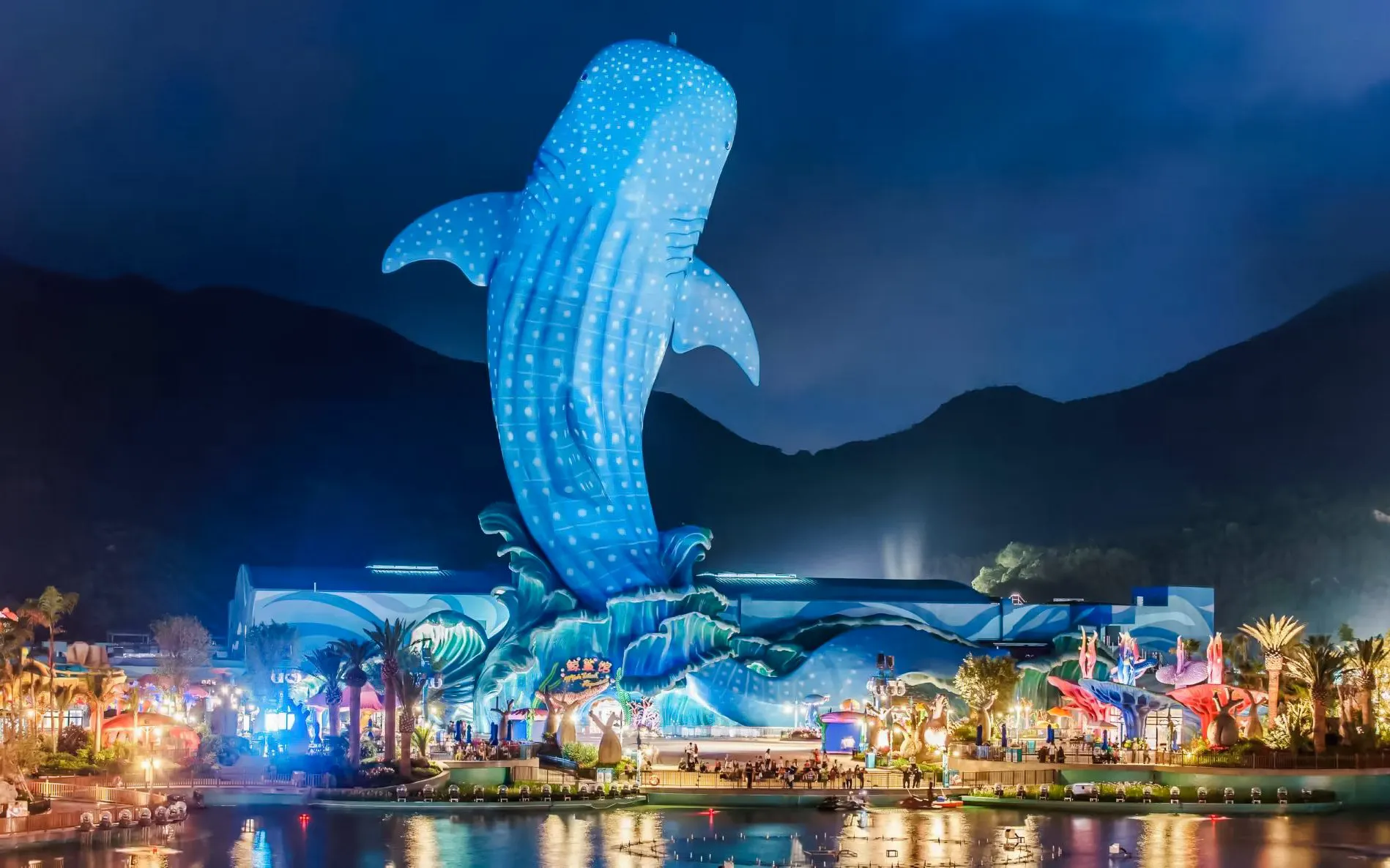 Giant blue whale statue and fountain at Chimelong Ocean Kingdom, Zhuhai, China, illuminated at night.
