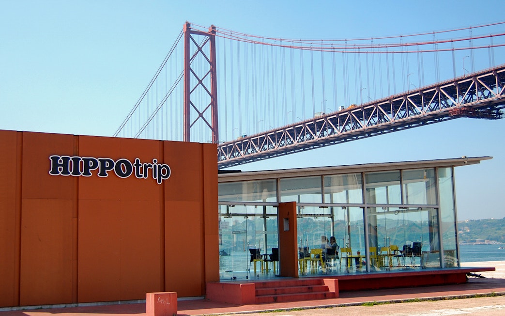 HippoTrip building with 25 de Abril Bridge in Lisbon, Portugal.