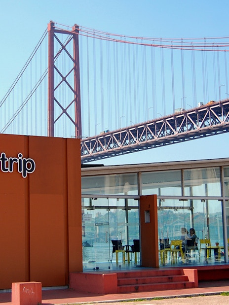 HippoTrip building with 25 de Abril Bridge in Lisbon, Portugal.
