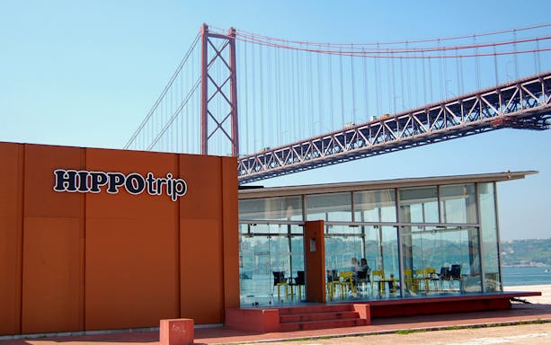 HippoTrip building with 25 de Abril Bridge in Lisbon, Portugal.