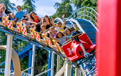 Families enjoying the Tom and Jerry roller coaster at Parque Warner Madrid.