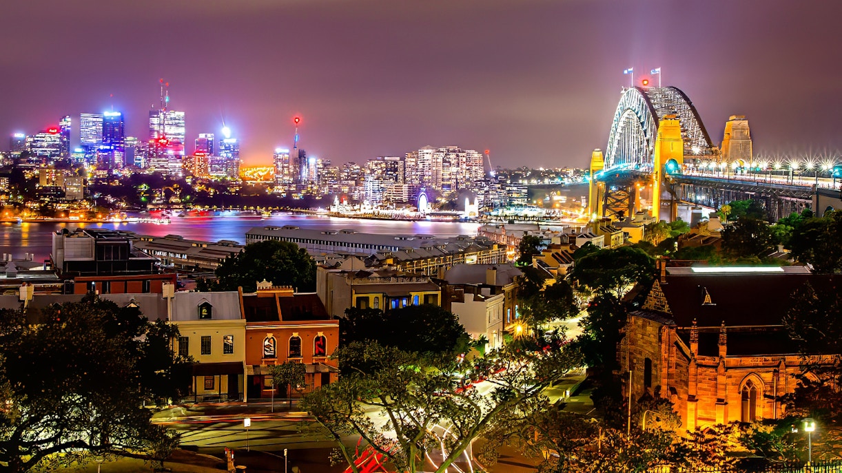 Sydney Harbour Bridge and city skyline illuminated at night during Sydney Night Tour.