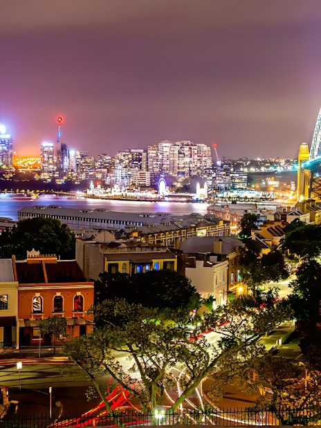 Sydney Harbour Bridge and city skyline illuminated at night during Sydney Night Tour.