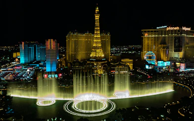 Eiffel Tower replica and Bellagio Fountains at night, Las Vegas Strip.