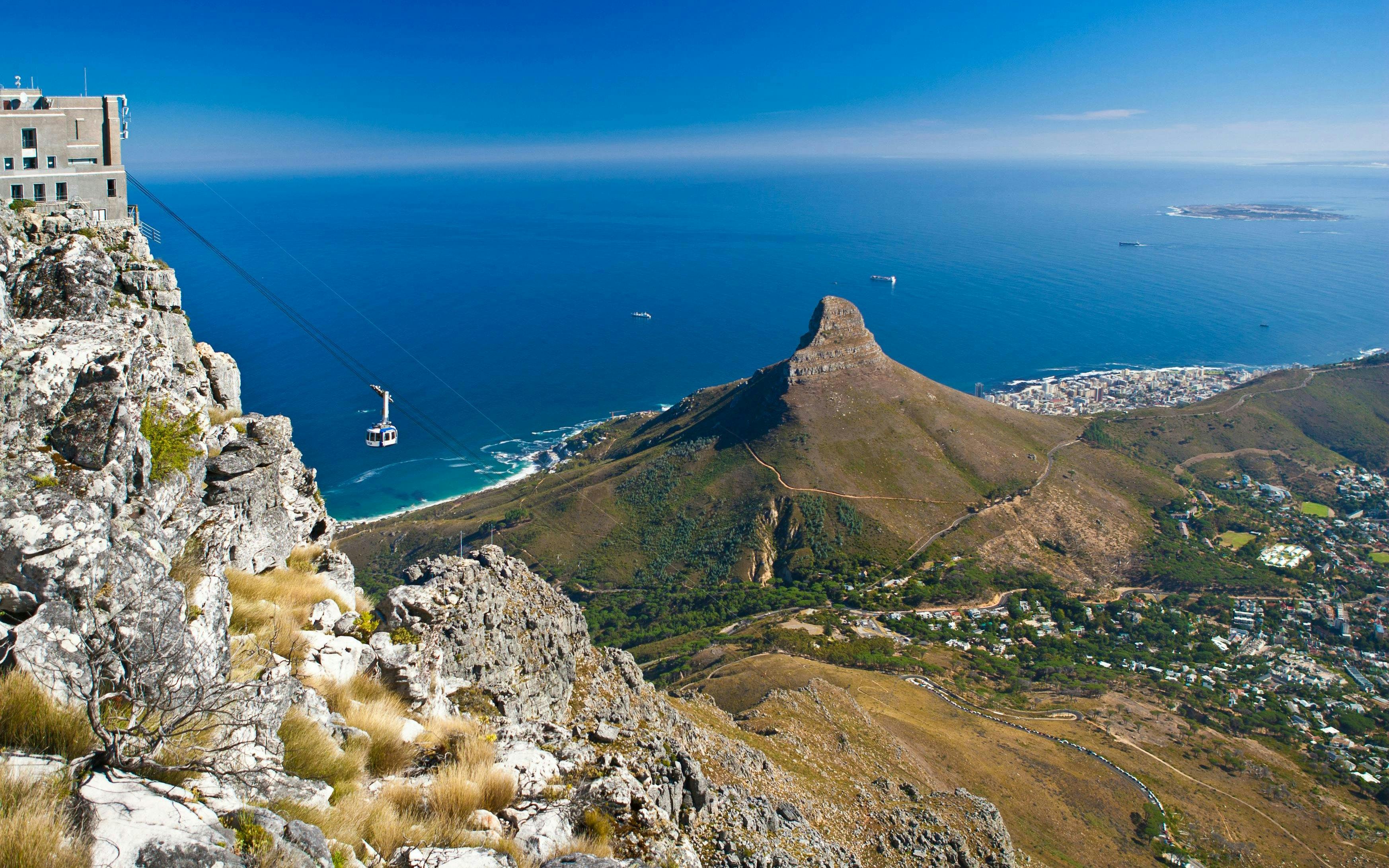 Cable car ascending Table Mountain with view of Lion's Head and Cape Town, South Africa.
