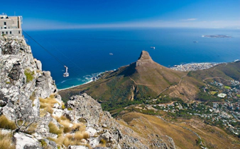 Cable car ascending Table Mountain with view of Lion's Head and Cape Town, South Africa.