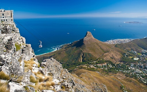 Cable car ascending Table Mountain with view of Lion's Head and Cape Town, South Africa.