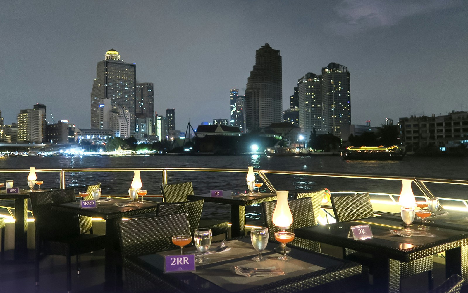 Chao Phraya Princess Cruise dining experience with live music, Bangkok skyline in the background.