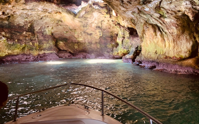 Boat exploring a cave in Polignano a Mare, Italy.