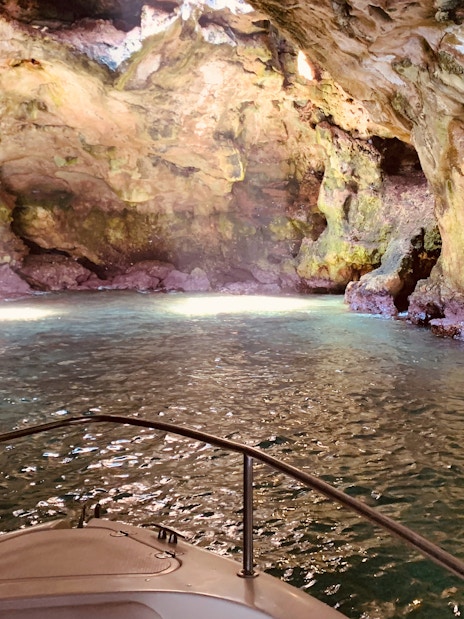 Boat exploring a cave in Polignano a Mare, Italy.