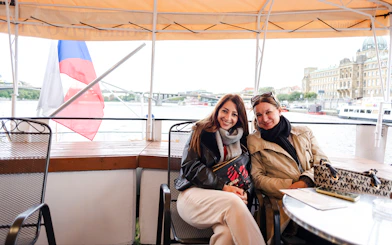 Tourists enjoying a sightseeing cruise on the Vltava River in Prague.