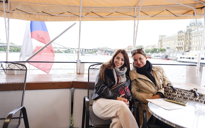 Tourists enjoying a sightseeing cruise on the Vltava River in Prague.