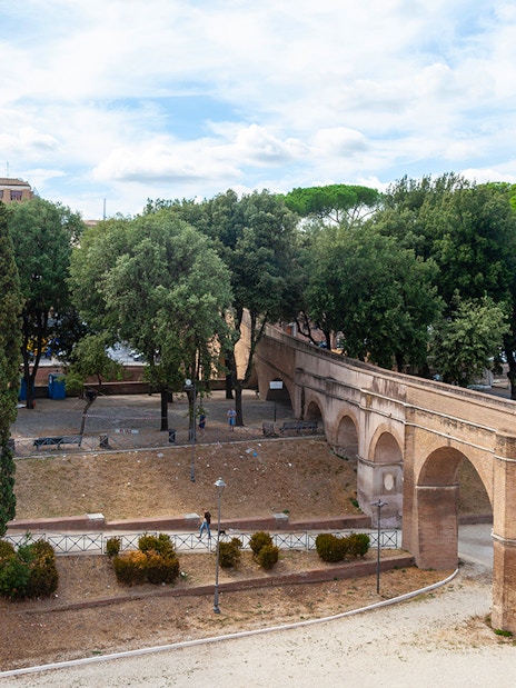 Passetto di Borgo walkway in Rome with trees and historic arches.