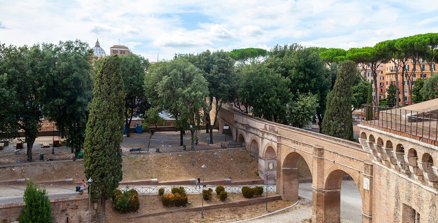 Passetto di Borgo walkway in Rome with trees and historic arches.