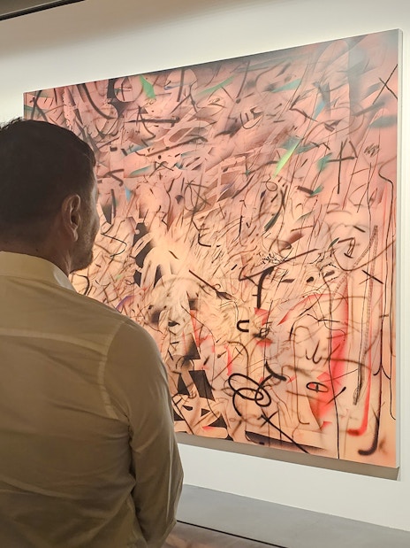 Man viewing abstract painting at Centre Pompidou Malaga exhibition.