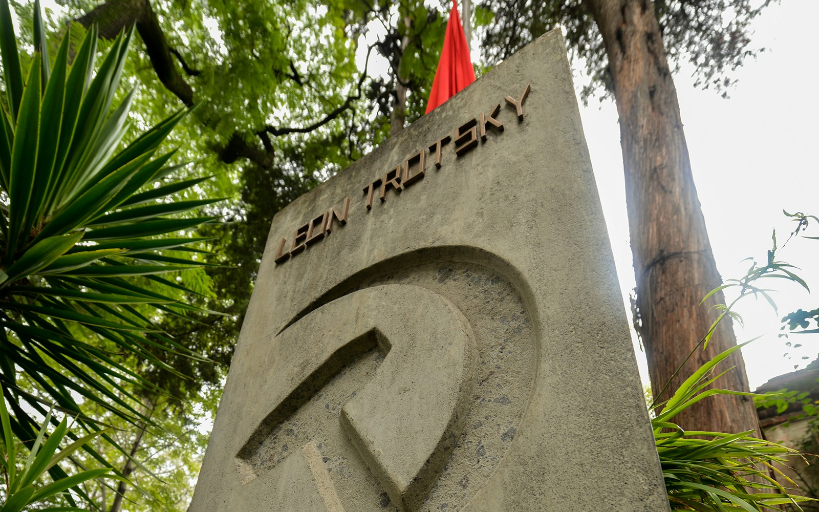 Leon Trotsky's tomb surrounded by lush greenery in Mexico City.