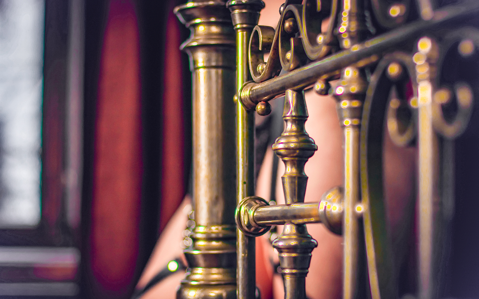 Ornate brass bed frame detail in a vintage bedroom setting.