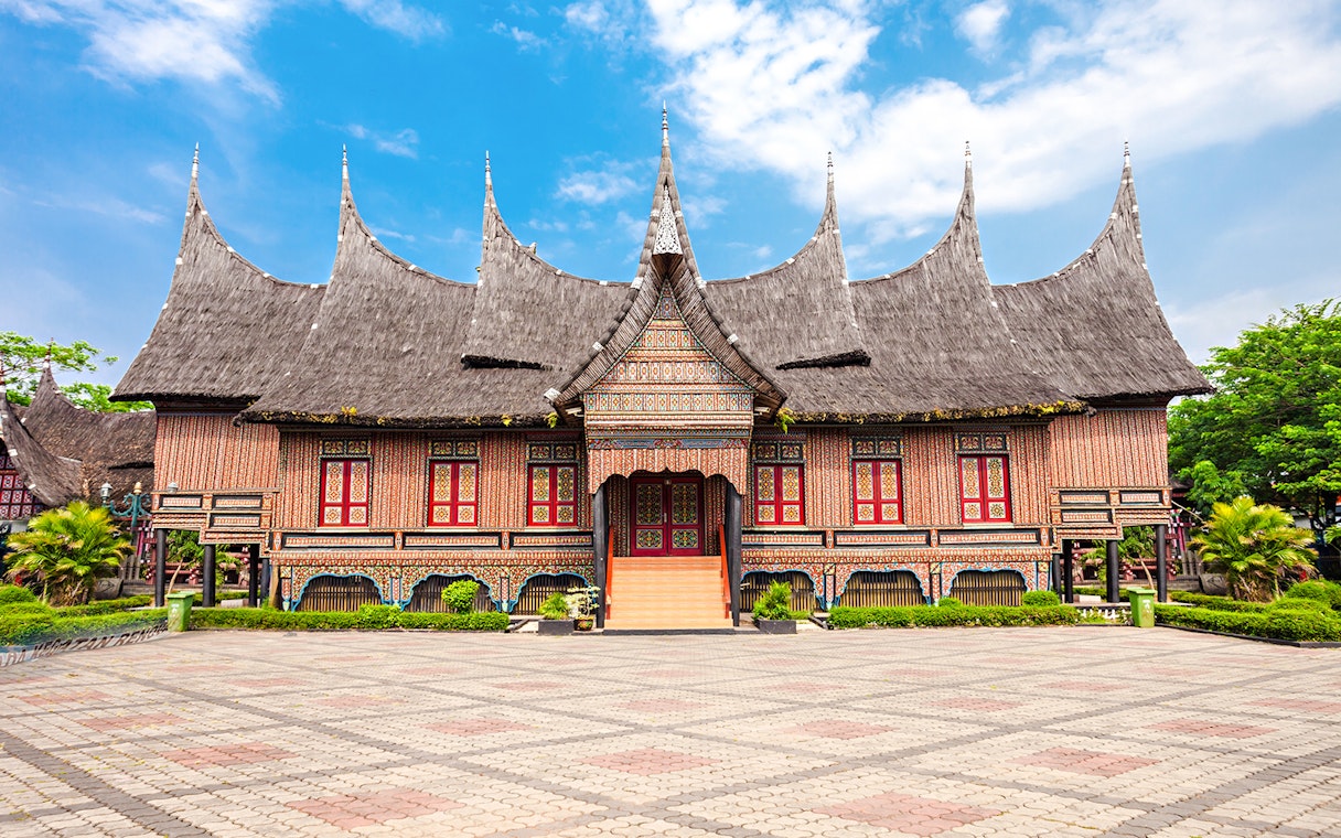 Traditional Indonesian house with ornate roof at Taman Mini Indonesia.
