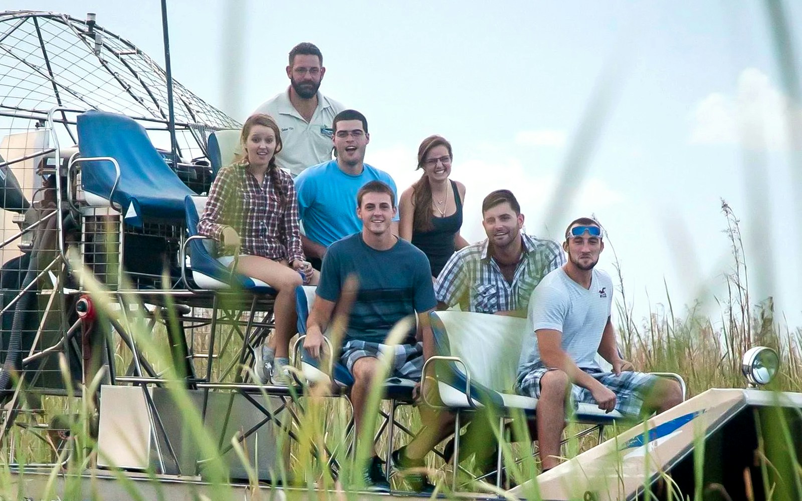 Group enjoying an Everglades airboat ride through marshland.