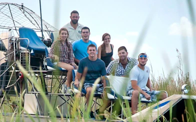 Group enjoying an Everglades airboat ride through marshland.