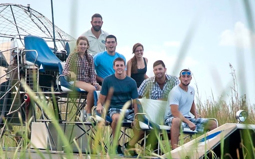 Group enjoying an Everglades airboat ride through marshland.