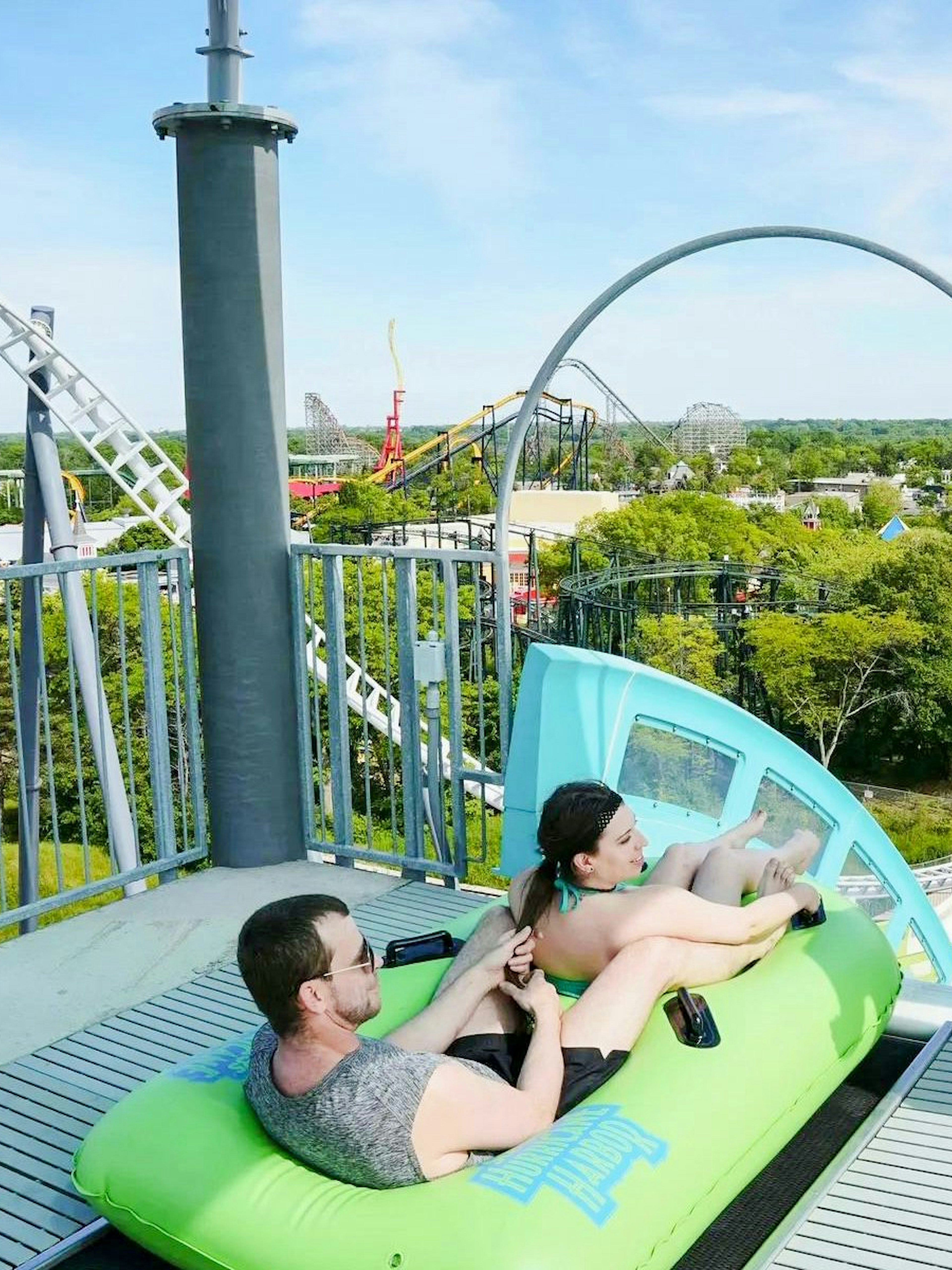 Visitors on a water slide at Hurricane Harbor Chicago with a lifeguard nearby.