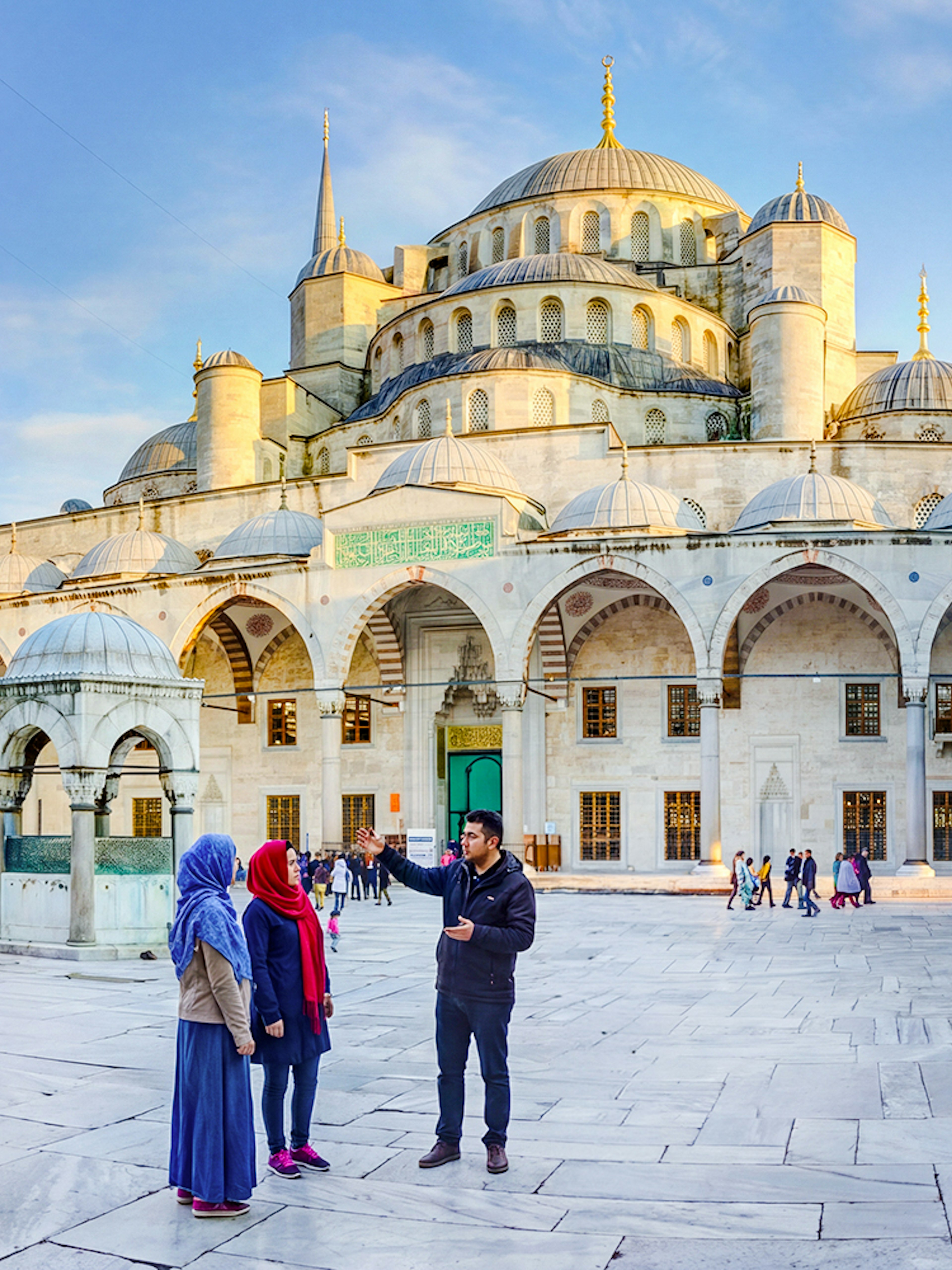 Visitors exploring the courtyard of the Blue Mosque in Istanbul, Turkey.