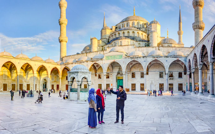 Visitors exploring the courtyard of the Blue Mosque in Istanbul, Turkey.