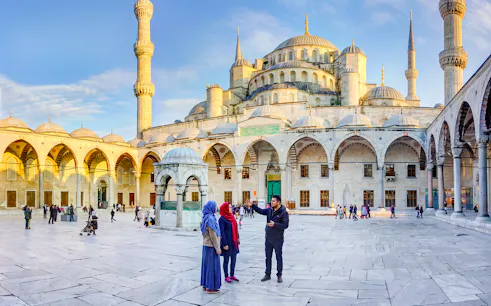 Visitors exploring the courtyard of the Blue Mosque in Istanbul, Turkey.