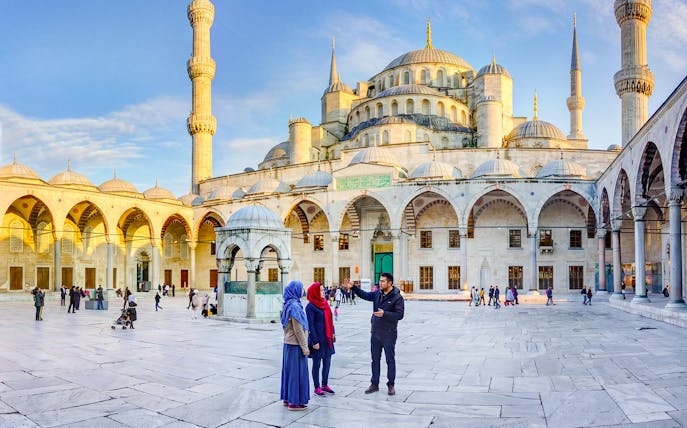 Visitors exploring the courtyard of the Blue Mosque in Istanbul, Turkey.
