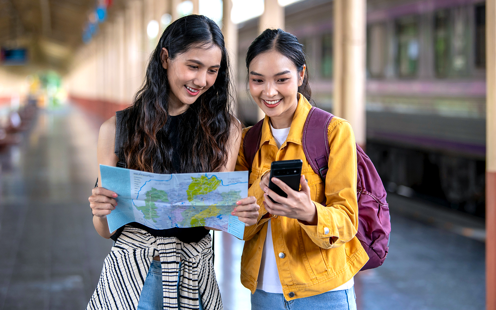 Two women examining a map for travel planning.