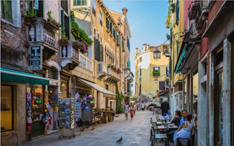 Venice street scene with cafes and shops, part of the Holy Heist city exploration game.