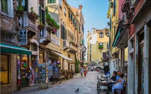 Venice street scene with cafes and shops, part of the Holy Heist city exploration game.