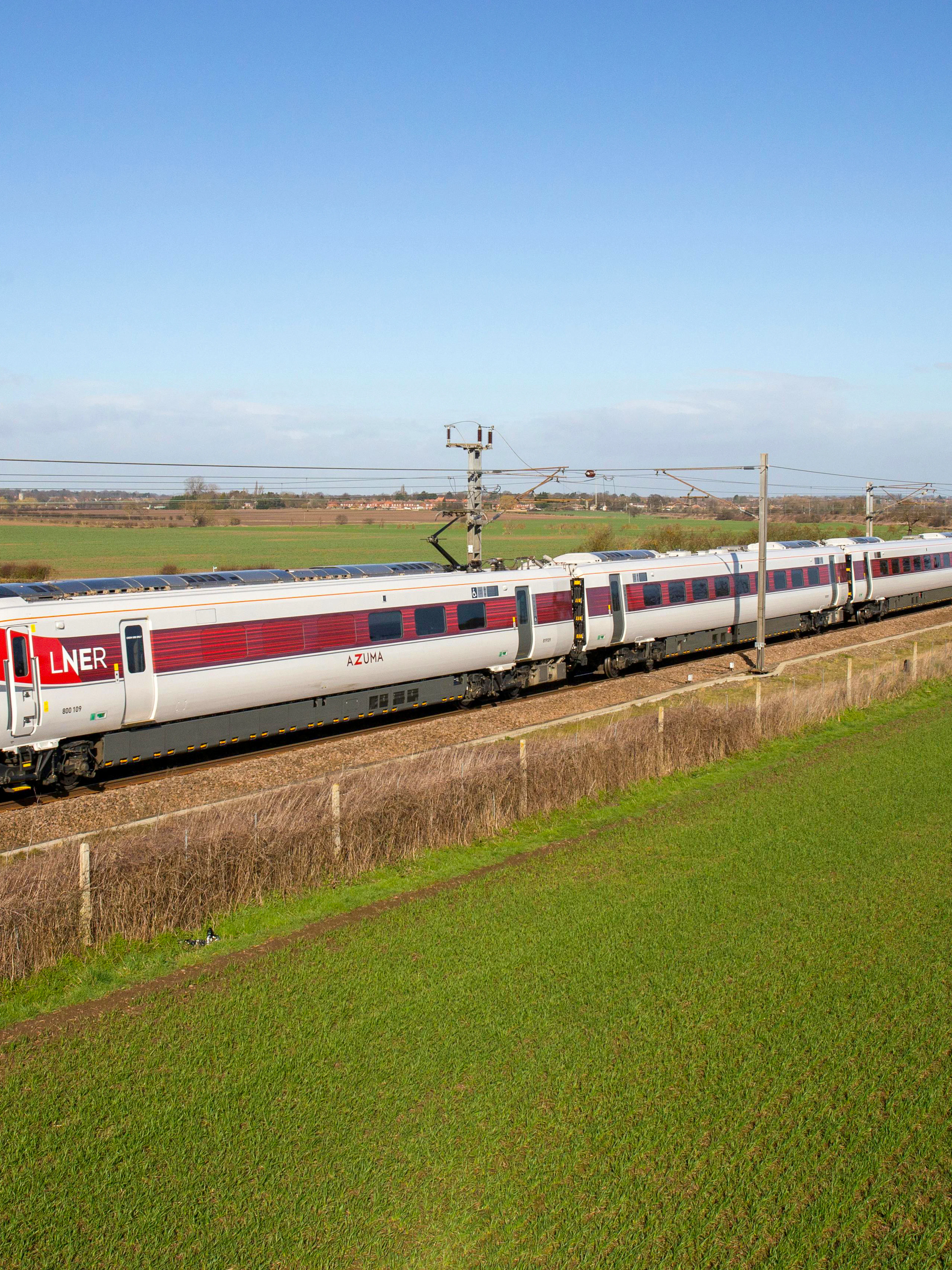 Train traveling through countryside on the National Rail network in England.