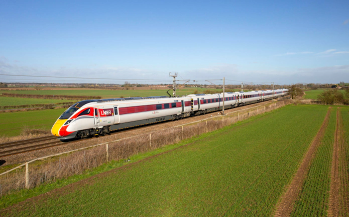 Train traveling through countryside on the National Rail network in England.