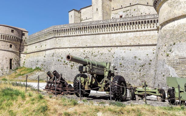 San Leo Fortress with historic cannons displayed in the courtyard, Italy.