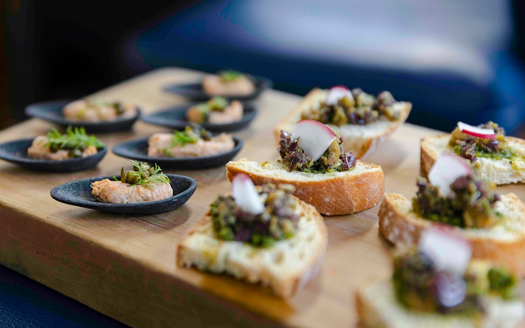 Canapes served on a wooden board during the Overnight Milford Cruise.