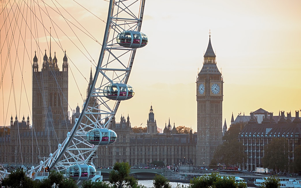 London Eye with Big Ben and Houses of Parliament at sunset.