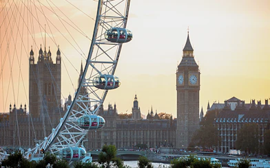 London Eye with Big Ben and Houses of Parliament at sunset.