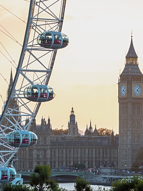 London Eye with Big Ben and Houses of Parliament at sunset.