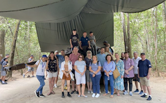 Group of tourists at Cu Chi Tunnels site during VIP premium speed boat tour.