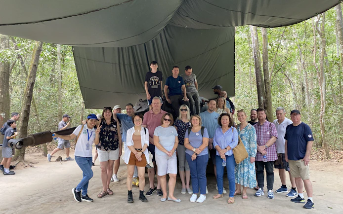 Group of tourists at Cu Chi Tunnels site during VIP premium speed boat tour.