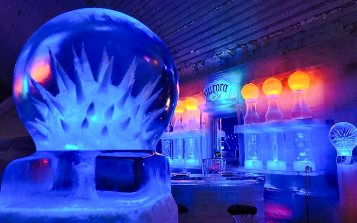 Aurora Ice Bar with ice sculptures and colorful lights on Chena Hot Springs Day Tour.