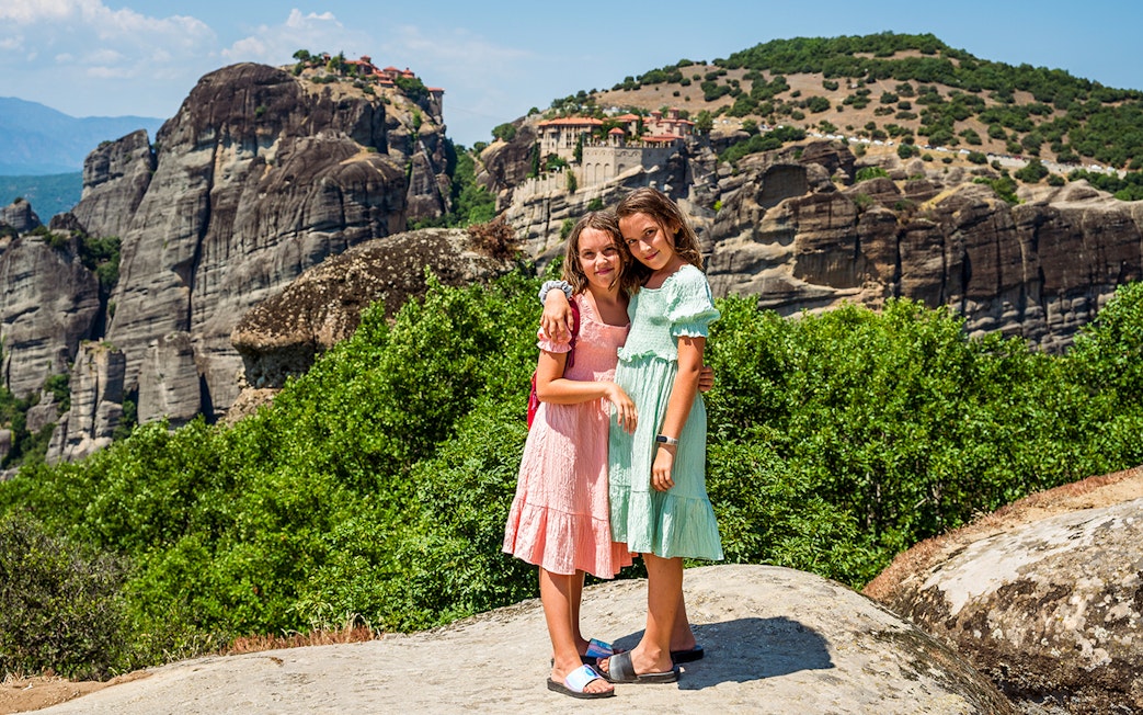Two children standing on a rock with Meteora monasteries in the background, Thessaloniki tour.